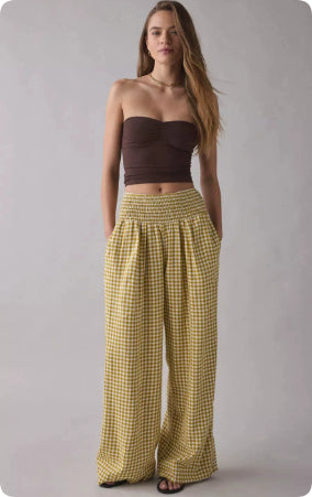 Mustard yellow checked wide-leg pants with a smocked waistband, styled with a brown bandeau top