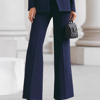 Navy flare pants, front view with black quilted handbag