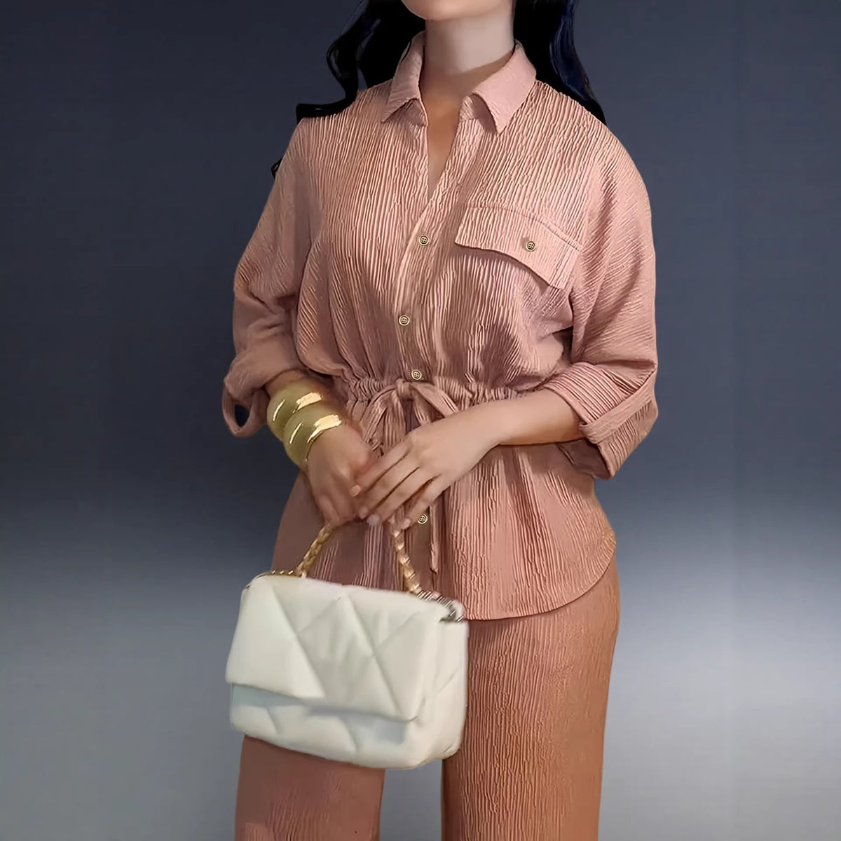 Dusty rose belted shirt with lapel collar and a white quilted handbag, close-up