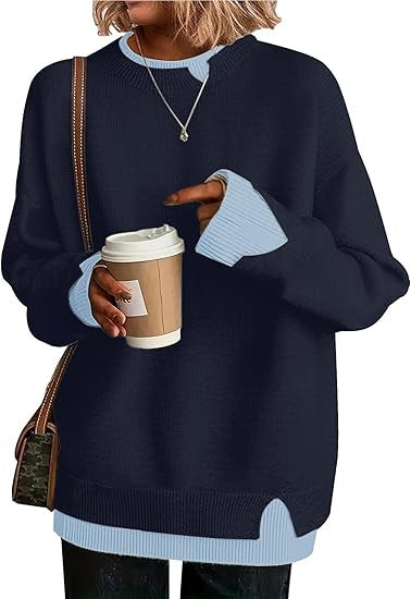 Double-layer crewneck sweater in navy with light blue layered cuffs and hem, styled with a shoulder bag, front view