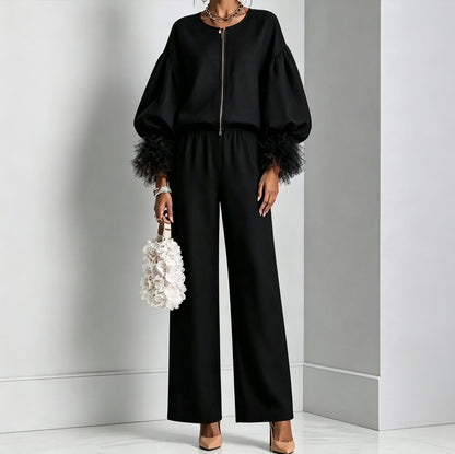 Black zip-front balloon sleeve top with feather-trim cuffs and wide-leg pants