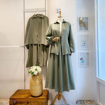 Olive green shirt and skirt set displayed on mannequins in a boutique