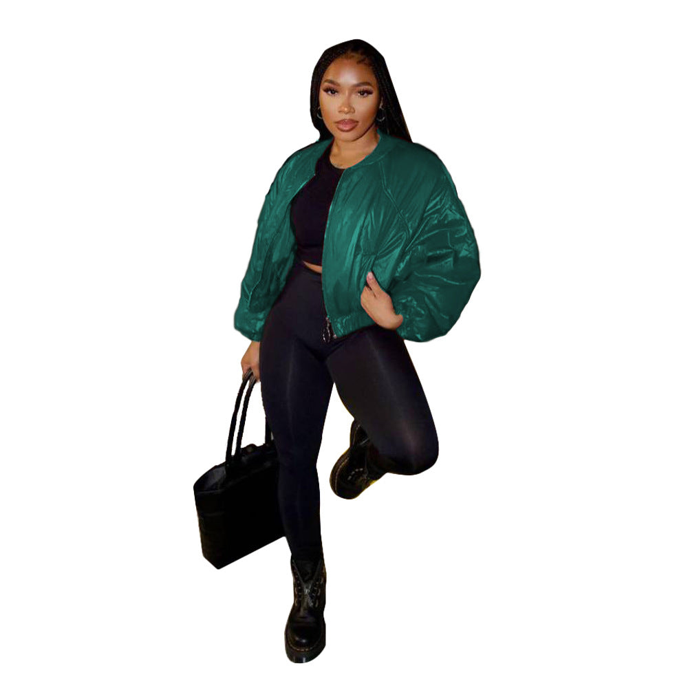 Emerald green cropped bomber jacket styled with black pants and a black handbag