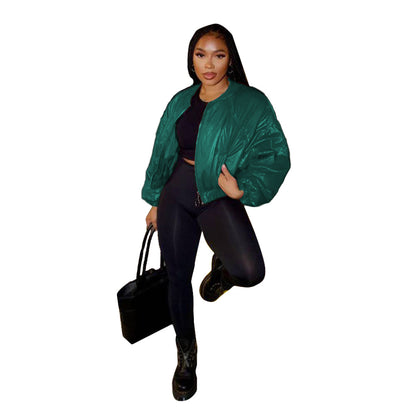 Emerald green cropped bomber jacket styled with black pants and a black handbag